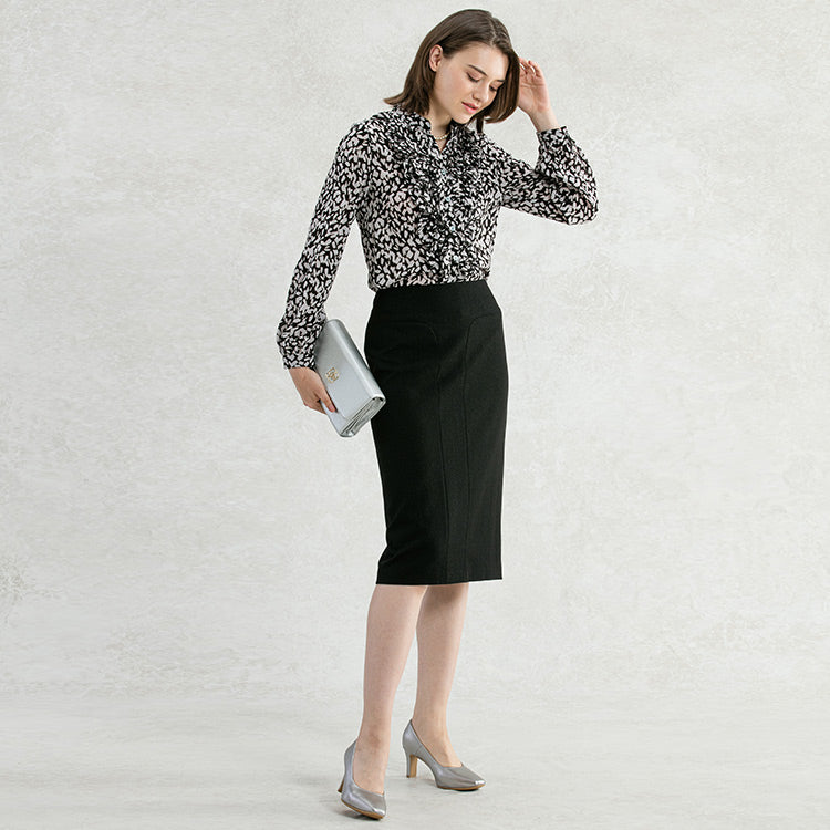 Black tones down a frilly blouse