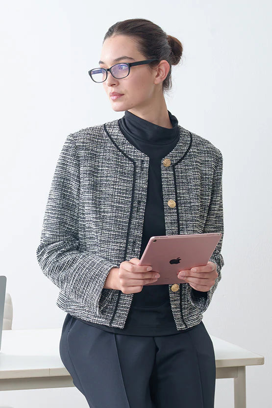 Woman in a checkered blazer holding a pink tablet against a white background